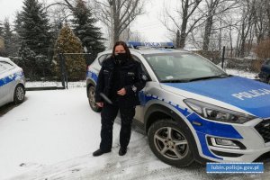 Policjanta stoi przy radiowozie