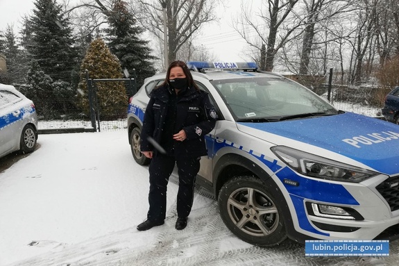 Policjanta stoi przy radiowozie