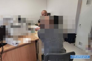 Policjant przesłuchuje podejrzanego mężczyznę