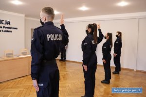 Policjanci mając podniesioną prawą rękę do góry  składają ślubowanie