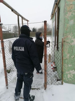 Policjanci i pracownik socjalny przy altanie ogrodowej