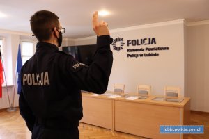 Policjant z podniesioną prawą ręką ślubuje