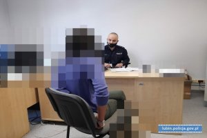 Policjant przesłuchuje kobietę