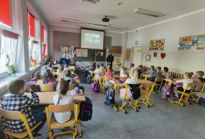 Policjantka prowadzi prelekcję z uczniami w klasie