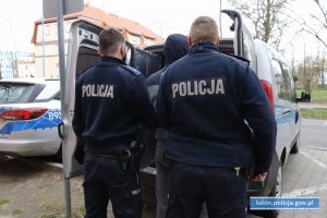 Policjanci z zatrzymanym przy radiowozie