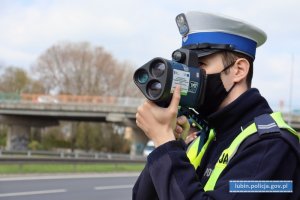 Policjant mierzy prędkość kierującym pojazdami