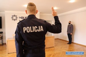 Policjant podczas składania roty ślubowania z prawą ręką podniesioną do góry