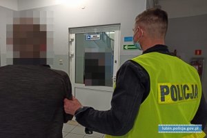 Policjant stoi z mężczyzną, podejrzanym o kradzież