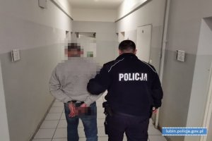 Policjant prowadzi zatrzymanego