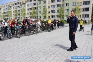 Policjant prowadzi prelekcję na temat bezpieczeństwa w ruchu drogowym uczniom klas czwartych szkół podstawowych