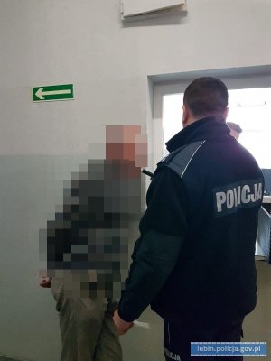 Policjant bada stan trzeźwości kierowcy