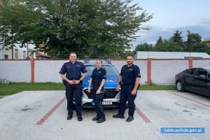 Policjanci stoją przy radiowozie