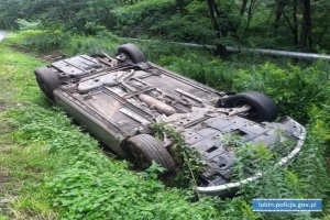 Auto przewrócone na dach leży w rowie.